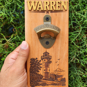Cedar bottle opener plaque personalized with gold Warren lettering and an engraved Lover’s Leap lighthouse in Jamaica.